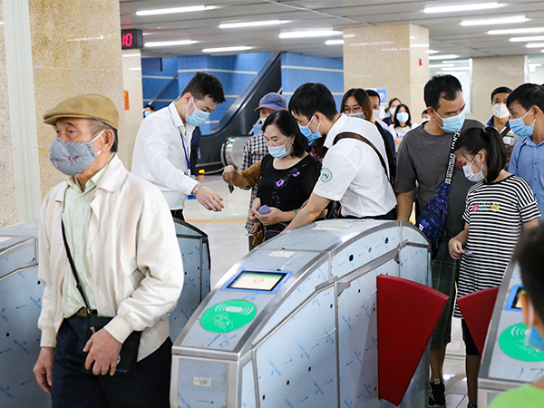 改札を通過する人々=21年11月、ベトナム・ハノイ市カットリン駅