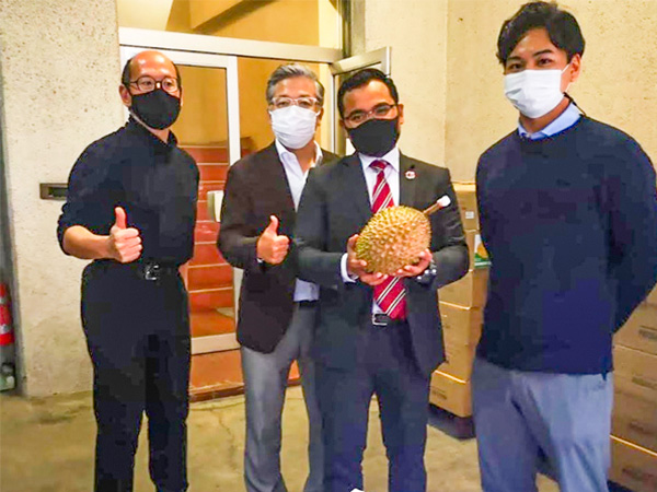 マレーシアから空輸されたドリアンを囲む、かをり果樹園の斎藤社長(左から2人目)ら(同社提供)