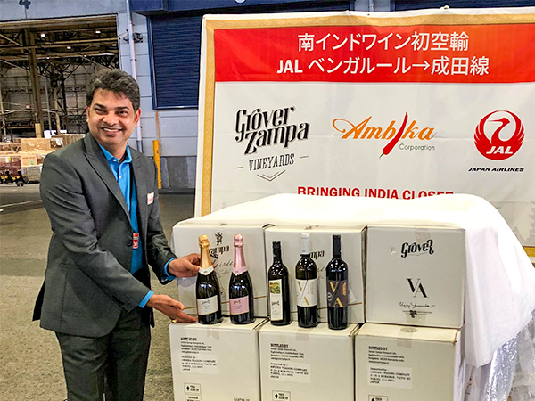 インド南部ベンガルールから到着したワインと、アンビカのニッティン代表=6日、成田空港(JAL提供)