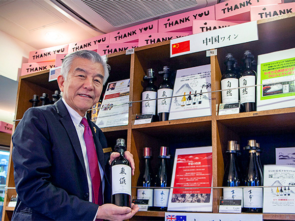 トゥエンティーワンコミュニティは、キャンペーン後も継続して中国産ワインを取り扱う。ワインショップのセラーマスター、江畑進一氏が手に取るのはプレミアム自然派ワイン「ル・シズィエム・エレマン」(同社提供)